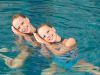 Duo of waterdancer girls in the pool doing routine, duets program