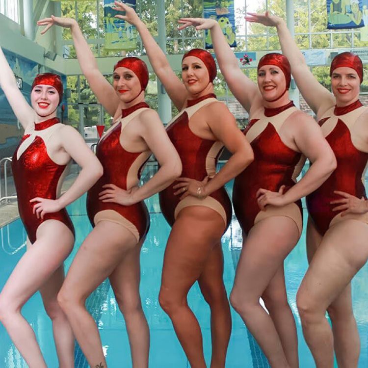 Group of ladies posing in the Masters Program with red bathing suits