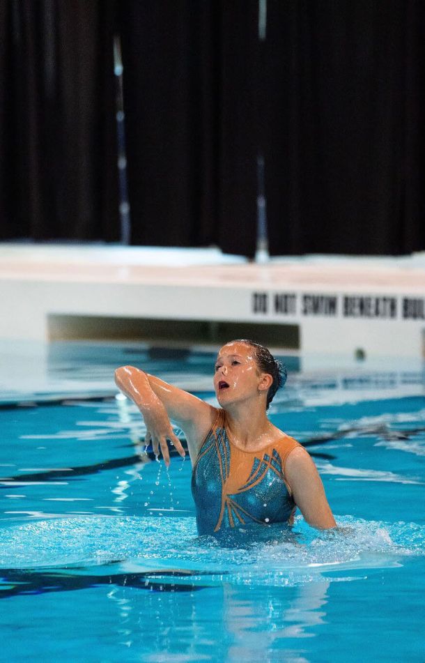 Waterdancer girl doing artistic swimming routine in the pool, Aquago program