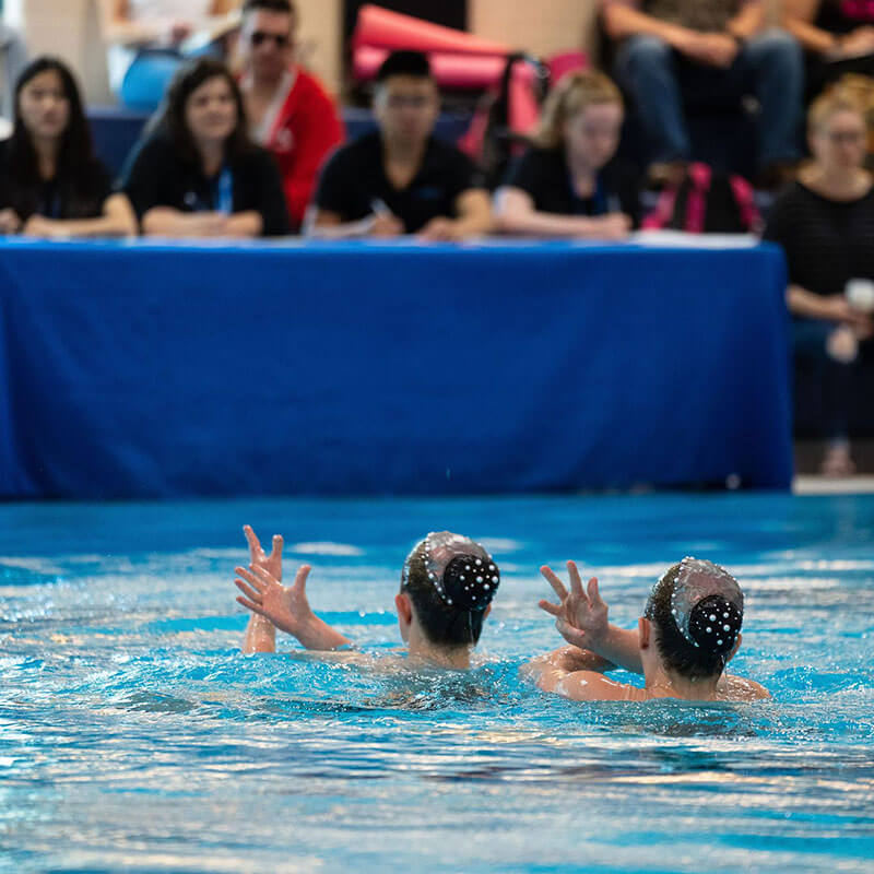 Two waterdancers performing in pool, Solo Duets Program