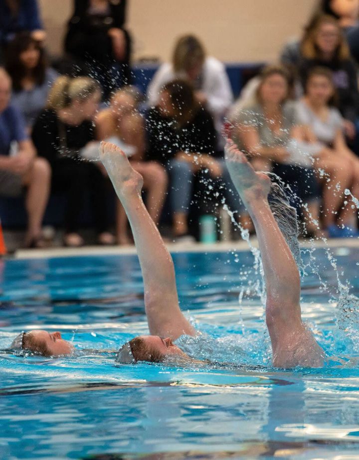 Ravensong Waterdancer hoisting member out of the water with crowd watching behind them