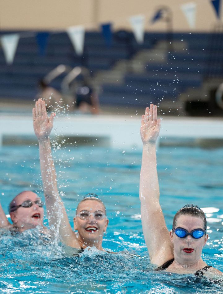 Team of synchronized swimmers getting ready to descend into the pool, Masters Program